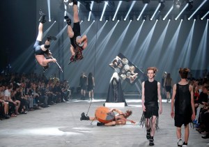 Winny Puhh ...Models wear creations by fashion designer Rick Owens as part of his men's fashion Spring-Summer 2014 collection, presented Thursday, June 27, 2013 in Paris, as Estonian metal/punk band Winny Puhh perform live, suspended by their feet . (AP Photo/Francois Mori)